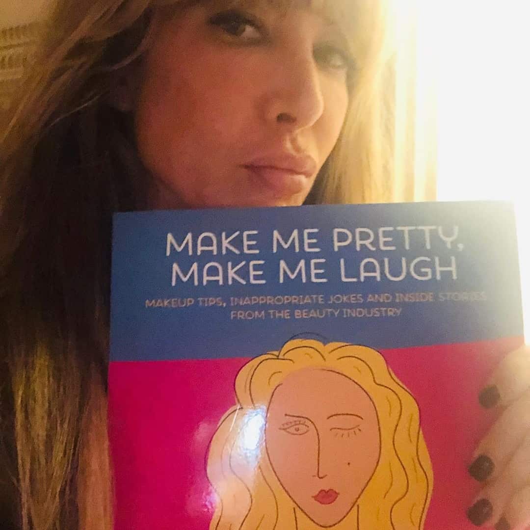 Amy Dresner holding a copy of Make Me Pretty, Make Me Laugh